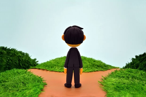 分かれ道の前で立ち止まる人間